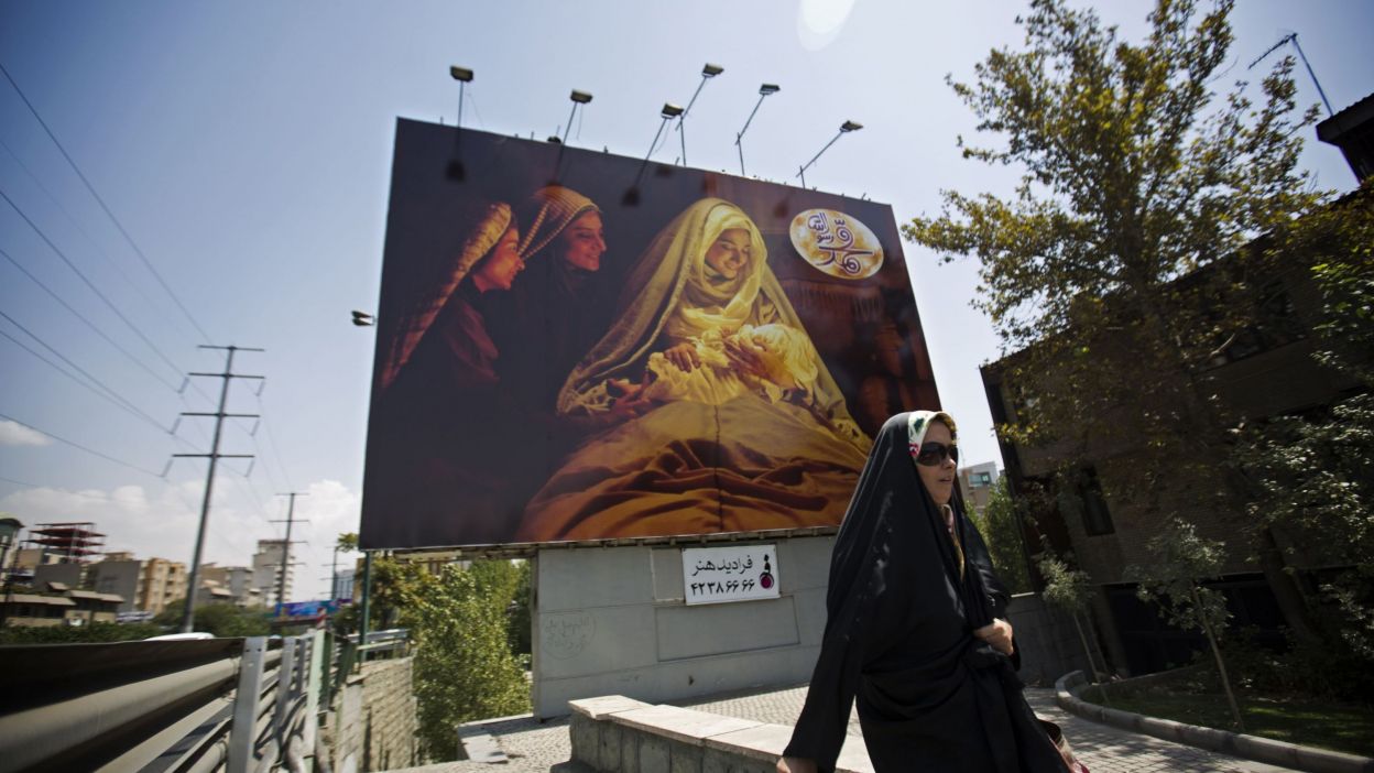 Une Téhéranaise devant une affiche du film « Mahomet »