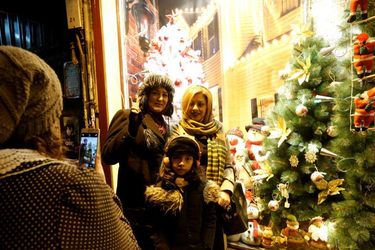 Des Iraniennes se font prendre en photo devant une vitrine de décorations de Noël dans des boutiques de Téhéran, le 24 décembre 2016. 